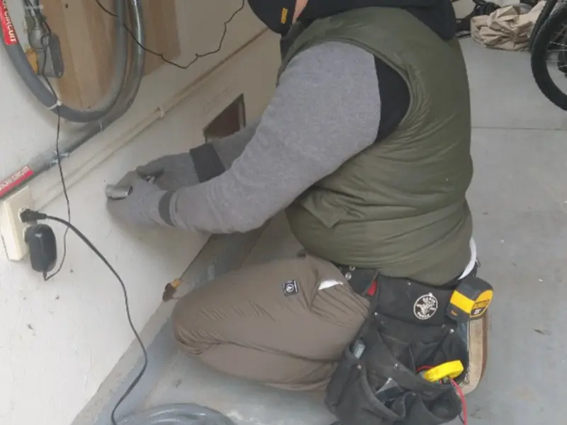 Electrician performing outlet wiring in a Conklin garage